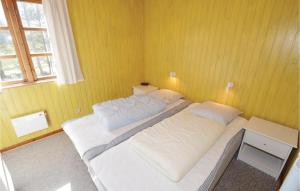 sypialnia z dużym łóżkiem w żółtej ścianie w obiekcie Nice Home In Lgstr With Kitchen w mieście Trend