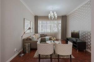 sala de estar con sofá, mesa y sillas en Modern Apartment in Rosebank en Johannesburgo