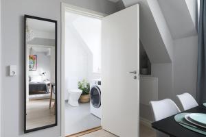 a bathroom with a washing machine and a mirror at Linne Studio in Uppsala