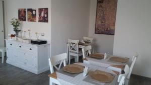 uma sala de jantar com mesa e cadeiras e uma cozinha em Venustas em Lampedusa