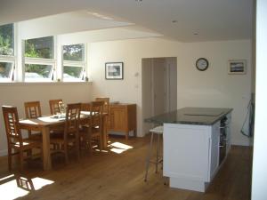 a kitchen and dining room with a table and chairs at Painter's House in Dunvegan