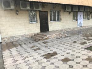 a building with a black door and a tiled floor at Paradise inn in Tashkent