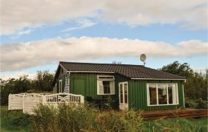a green tiny house sitting in a field at Beautiful Home In Rm With Kitchen in Bolilmark