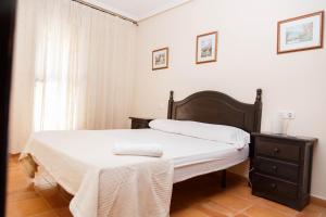 a bedroom with a bed and a dresser and a window at Apartamentos Atlas in Torrevieja