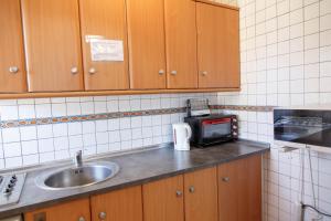 uma pequena cozinha com um lavatório e um micro-ondas em Apartamentos Atlas em Torrevieja