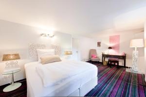 a bedroom with a white bed and a piano at Hotel Essgold in Ratingen