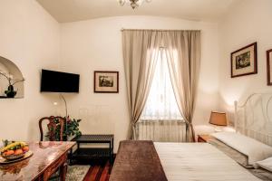 ローマにあるSuite Cancelloのベッドルーム1室(ベッド1台、テーブル、窓付)