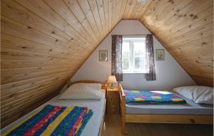 NeksøにあるAmazing Home In Nex With 2 Bedroomsの屋根裏部屋 窓付 ベッド2台付
