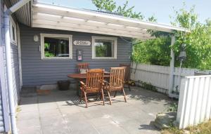 a patio with a table and chairs and a white pergola at Klitbo in Balke +4 photos