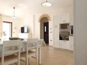 una cucina e una sala da pranzo con tavolo e sedie di Villino Turchese Budoni a Budoni