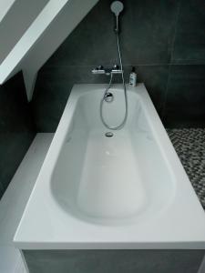 Kerautret Vian في Plougoulm: حوض استحمام أبيض مع دش في الحمام