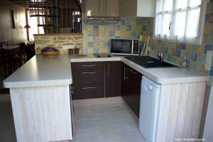 a kitchen with a counter top and a microwave at la p'tite maison in Feuguerolles-sur-Orne +14 photos