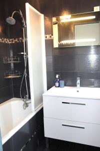 a bathroom with a white sink and a bath tub at Nice flat near Paris MCP in Joinville-le-Pont