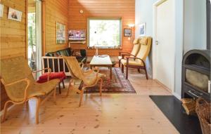a living room with chairs and a table and a fireplace at Four-Bedroom Holiday Home In Stege in Stege