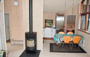 a room with a stove with a table and chairs at Nice Home In Vordingborg With 2 Bedrooms And Wifi in Næs