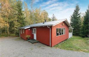 un capanno rosso con un portico in un cortile di Lrken a Bedegård