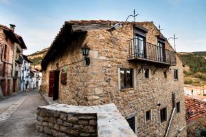 un antiguo edificio de piedra con balcón en una calle en Casa Rural Palacio, en Linares de Mora