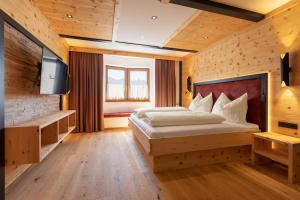 a bedroom with a bed and a flat screen tv at Hotel Hauserwirt in Münster