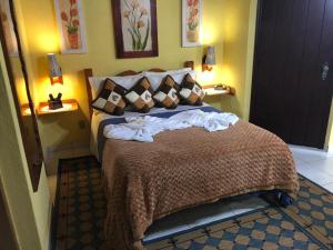 Una habitación de hotel con una cama con toallas. en Pousada Lago Azul, en Monte Verde