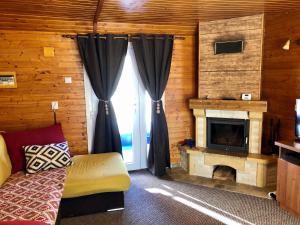 Cette chambre dispose d'une cheminée, d'un canapé et d'une fenêtre. dans l'établissement Charming Home by Feleacu, à Feleacu