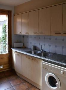 eine Küche mit einer Spüle und einer Waschmaschine in der Unterkunft Can Janpere I in Pardines