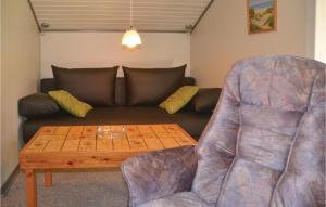 un salon avec un canapé, une table et une chaise dans l'établissement Holiday Home Fyrrekrogen Nørre Nebel Vi, à Lønne Hede
