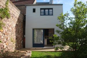 a house with a black door and a brick building at la p'tite maison in Feuguerolles-sur-Orne
