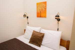 a bedroom with a bed with two lights on the wall at Stefanie's Rooms in Asprovalta