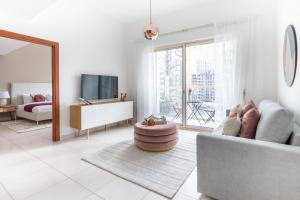 a living room with a couch and a tv at Frank Porter - Marina View Tower in Dubai