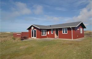 a red house with a black roof on a field at 3 Bedroom Cozy Home In Hvide Sande in Havrvig