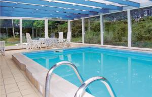 ロモ・キルケビーにあるBeautiful Home In Rm With 4 Bedrooms And Indoor Swimming Poolの青い天井と窓のあるスイミングプール