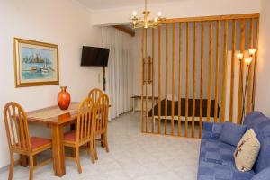 a living room with a table and a blue couch at Stefanie's Rooms in Asprovalta