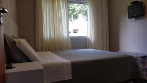 Un dormitorio con una cama y una ventana en Casa piscina próxima praia, en Florianópolis 25 fotos más