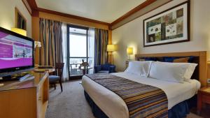 a hotel room with a bed and a flat screen tv at Crowne Plaza Beirut by IHG in Beirut