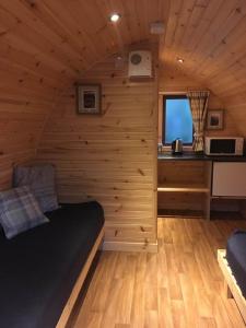 una camera con un letto in una cabina di legno di Glamping Hut - By The Way Campsite a Tyndrum