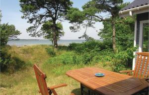 a wooden table with two chairs and a view of the water at Klitbo in Balke