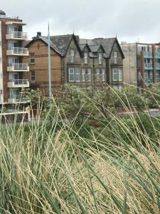 a building in the middle of a city with tall grass at Beach House in Lytham St Annes