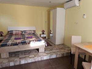 um quarto com uma cama grande e uma mesa em Apartman Andjela 2 em Vrdnik