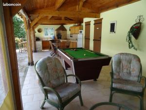 a living room with a pool table and two chairs at les chambres de Rocbaron in Rocbaron