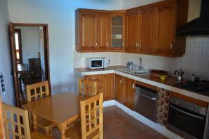 - une cuisine avec des placards en bois, une table et un four micro-ondes dans l'établissement Villa Garcia - Old Reformed Cortijo, à Sorbas