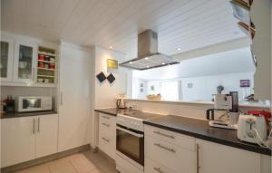 een keuken met witte kasten en een fornuis met oven bij Beautiful Home In Ebeltoft With Kitchen in Øksenmølle
