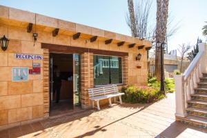 a building with a bench sitting outside of it at Apartamentos Atlas in Torrevieja