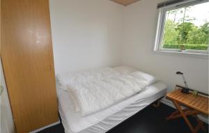 ein weißes Bett in einem Zimmer mit Fenster in der Unterkunft Cozy Home In Hjslev With House Sea View in Lund