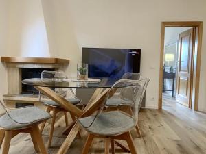 a dining room with a table and chairs and a tv at La Coroncina Lodging in Siena