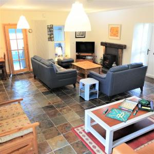 a living room with couches and a table at The Barn at BallyCairn in Larne