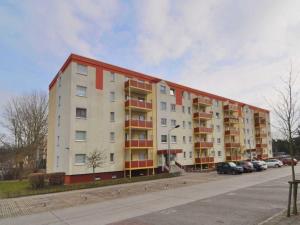 ein großes Apartmenthaus mit Autos auf einem Parkplatz in der Unterkunft Ferienwohnung Dünenweg Piepen in Heringsdorf