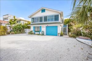 a large house with a blue garage at Seahorse Suite home in Bradenton Beach