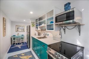 a kitchen with blue cabinets and a microwave at Seahorse Suite home in Bradenton Beach