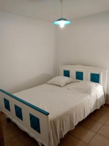 a bedroom with a white bed with a blue headboard at Gîte Etxe Xuri in Ossès