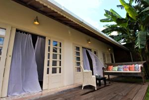 a porch with a bench on a wooden deck at Villa Ruby in Yogyakarta